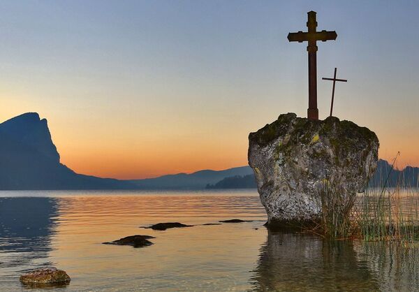 Ein See mit einer kleinen Insel, auf der zwei Kreuze stehen.