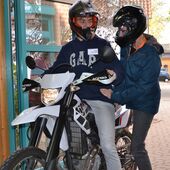 zwei Motorradfahrer mit Helm im Eingangsbereich der Pausenhalle