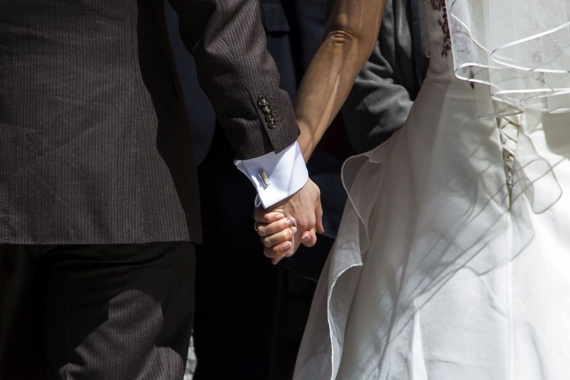 Hochzeitspaar von hinten, Hand in Hand