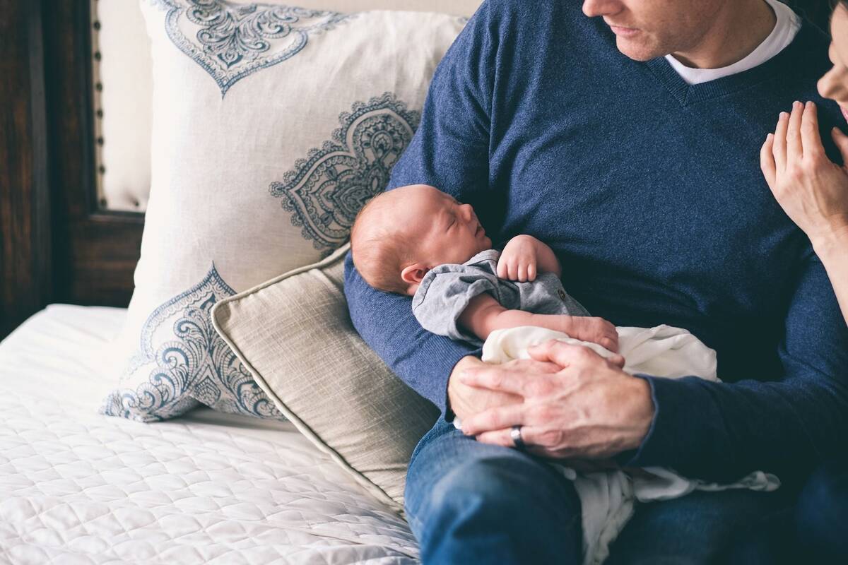 Kleines Baby, das vom Vater im Arm gehalten wird