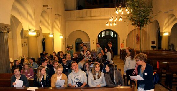 Jugendliche sitzen in den vorderen Kirchenbänken