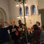 Jugendliche hängen ihre Wünsche an den heiligen Geist in die Zweige eines Baumes, der im Mittelgang der Kirche steht.
